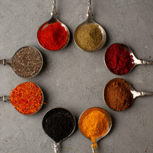 colorful-spices-hot-spicy-different-meal-inside-silver-spoons-grey-floor