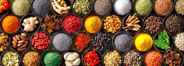 Colourful background from various herbs and spices for cooking in bowls. Top view